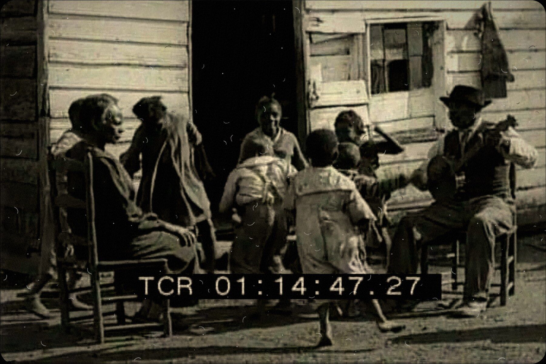 Musicians playing to a crowd on a wooden porch